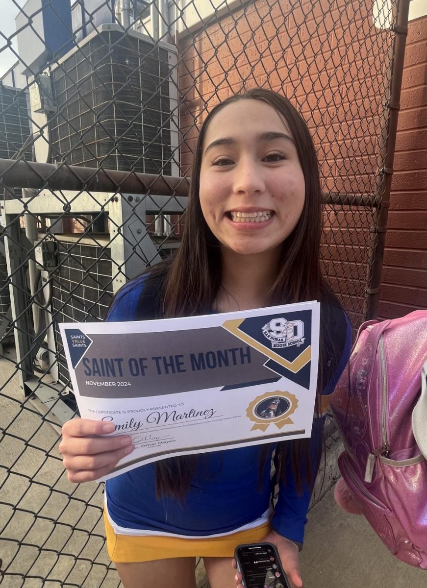 Photo of Freshman student Emily Martinez holding her Saint of the month certificate 